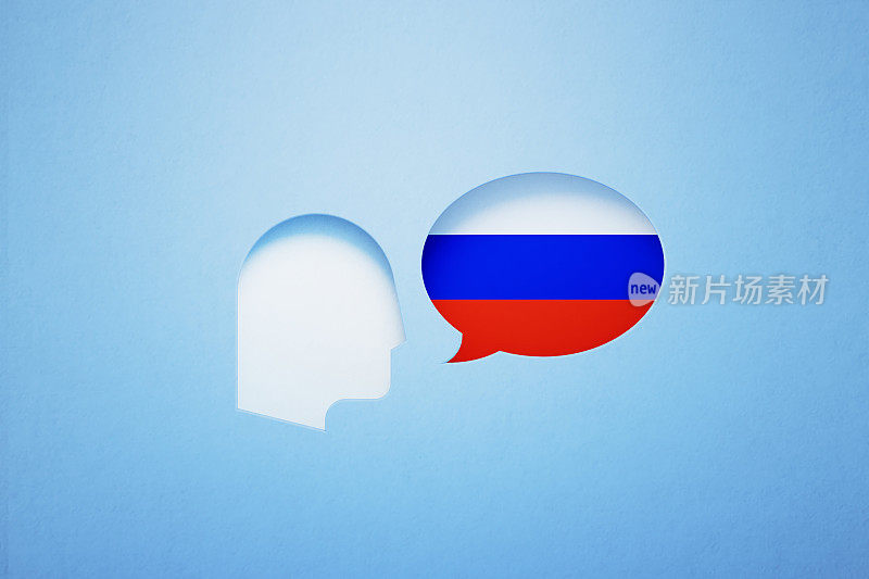 俄语学习和说话的概念-讲话气泡形状纹理与俄罗斯国旗坐在旁边一个切割出的人的头在蓝色的背景