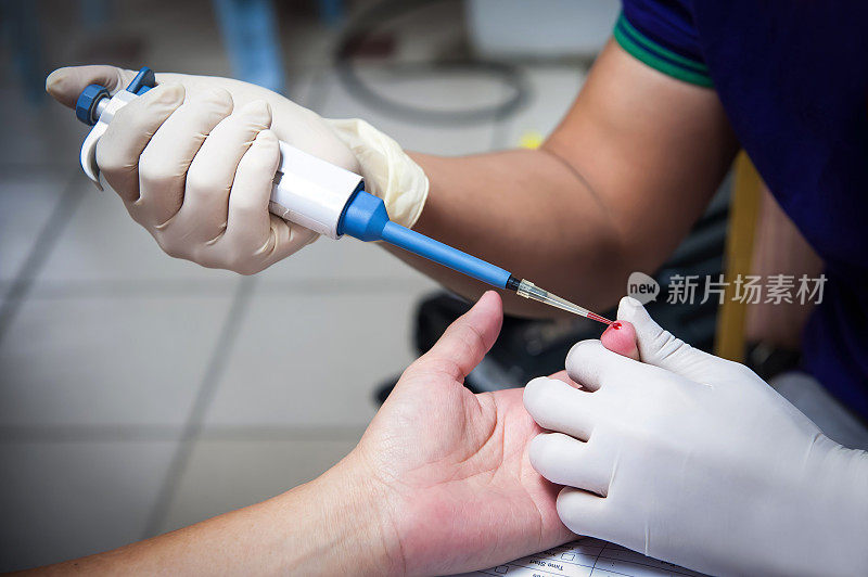 卫生工作者在献血过程中抽取男性献血者的血液样本
