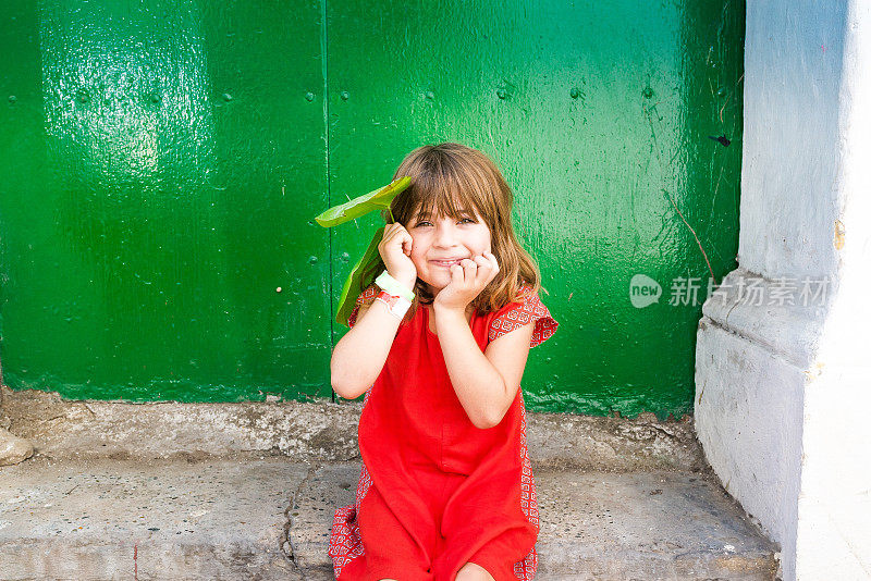 可爱的小女孩在一个古怪的肖像，红色的衣服在绿色的年代背景