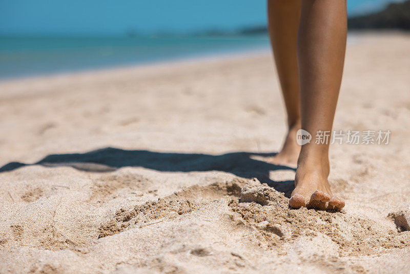 在泰国攀牙考拉的金色沙滩上，一名赤脚女子在行走。暑假的概念。