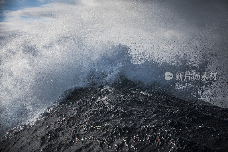 抽象的海浪冲破波涛汹涌的大海，黑暗的天空引人注目