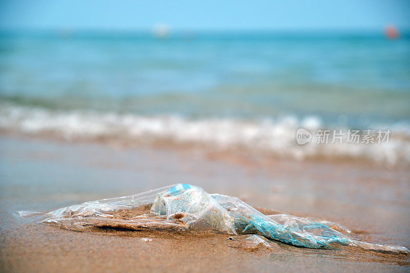 在沙滩上留下塑料袋垃圾。海岸上空的用过的脏垃圾。环境污染。生态问题