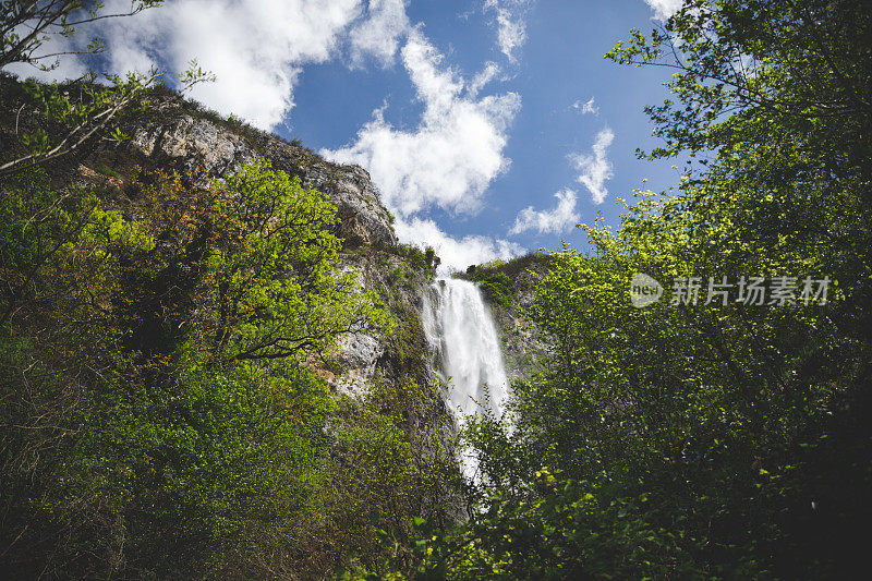 壮观的瀑布位于法国阿尔卑斯山脉绿色的夏季山脉中