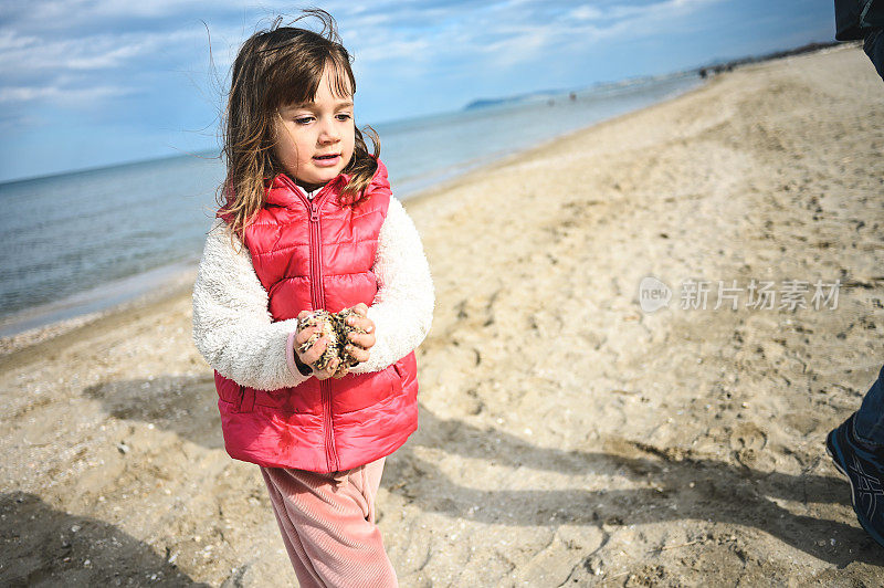 小女孩在玩海沙。