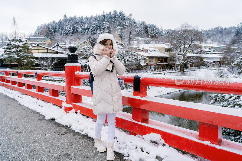 美丽的女子游客享受他们的日本之旅在雪的冬天。