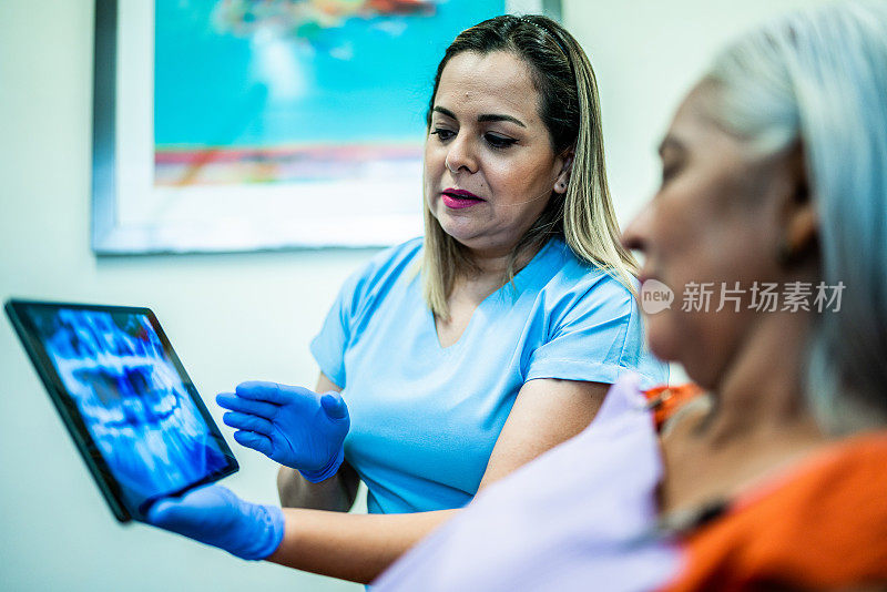 牙医在诊所里给一个成熟的女人看x光片