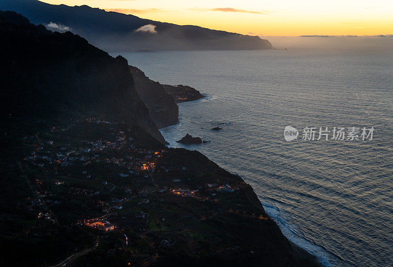 黄昏时分，从高角度欣赏建在海岸边绿色山谷中的传统葡萄牙村庄的景色