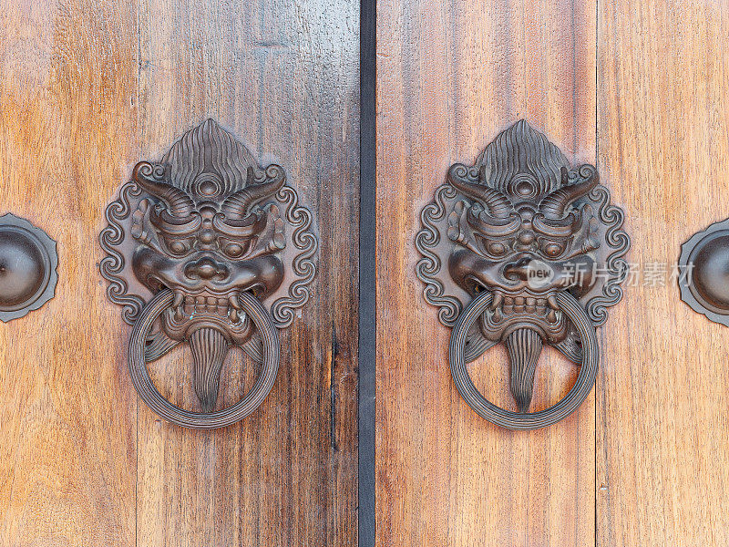木门上的老中式门把手，古色古香的东方门环。带有黄铜狮子头门环的传统中国门