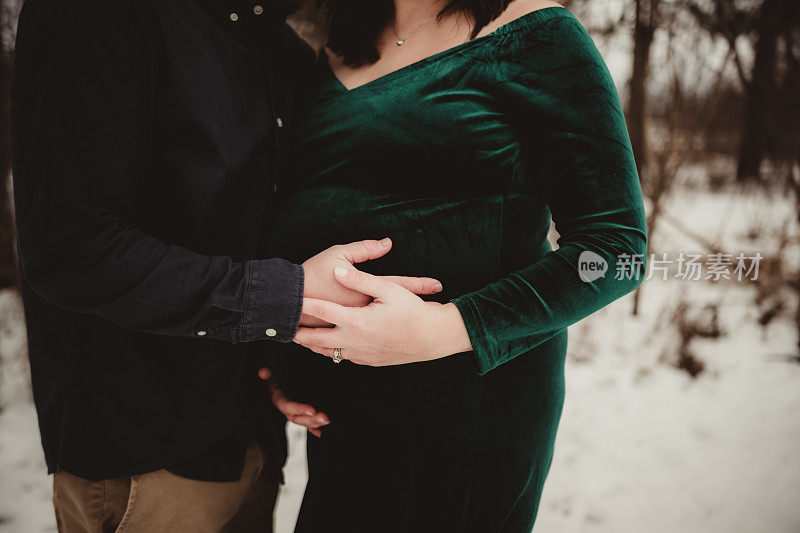 男人和女人抱着怀孕妻子的肚子