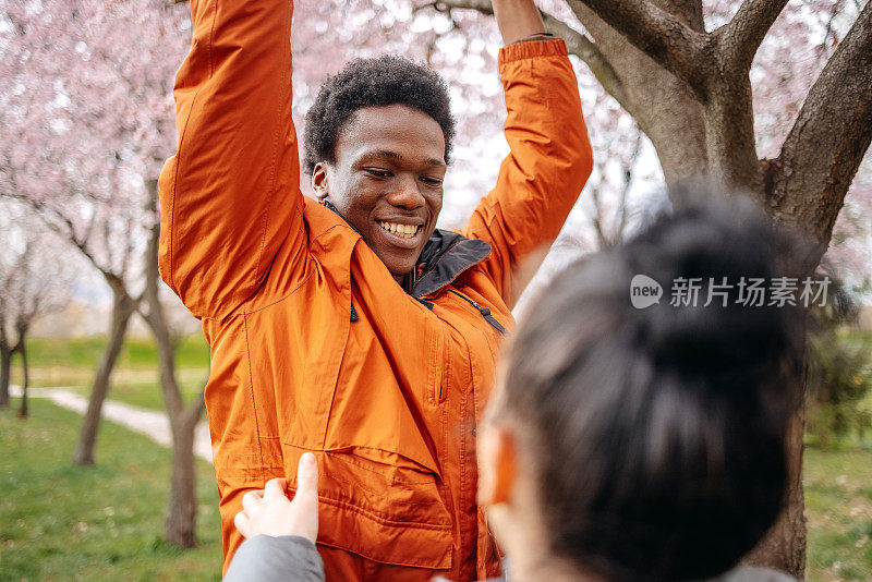 多种族夫妇在城市公园里春游，挂在树枝上