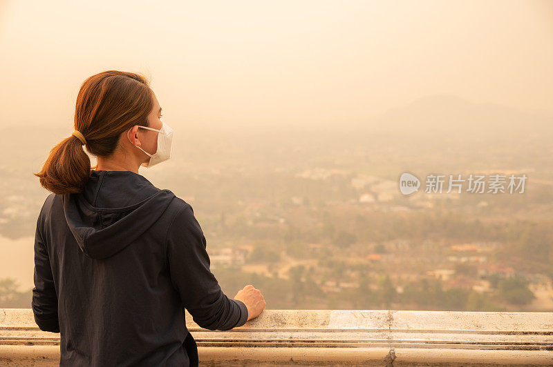 一名亚洲妇女戴着N95口罩来保护严重的空气污染。