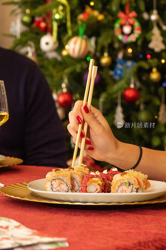 圣诞节用筷子在桌子上吃寿司