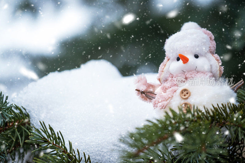 一个可爱的雪人玩具在雪地上。