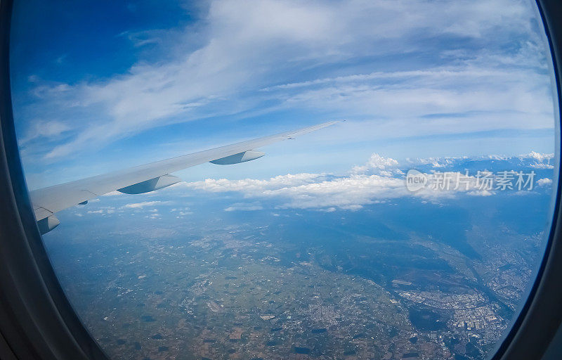鱼眼看天空。从飞机的窗户往外看。在陆地的顶端，有云和蓝天的大陆。