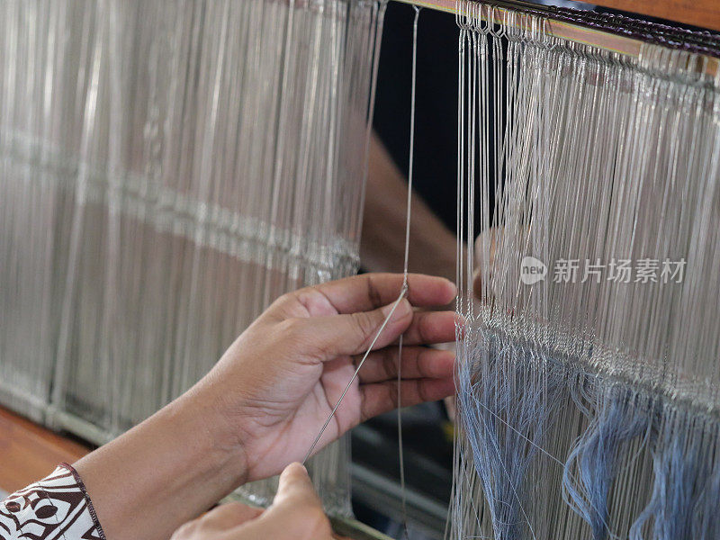 选择重点传统织造机正在准备纱线。在开始编织伊卡特之前准备织机