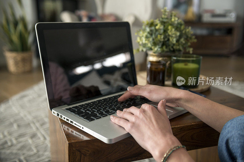 一个女人在空白的笔记本电脑上打字