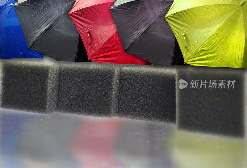 五颜六色的雨伞放在海绵泡沫垫上