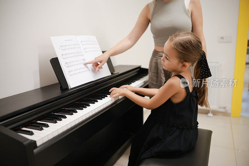 青年钢琴家老师教女童学生弹钢琴、音乐教育的理念
