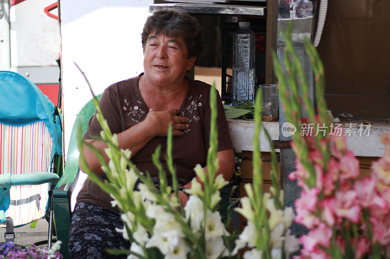 年长的妇女在街上卖花