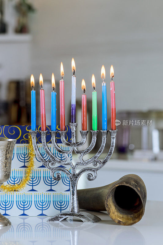 一支蜡烛点燃了光明节烛台，象征着犹太节日的光明