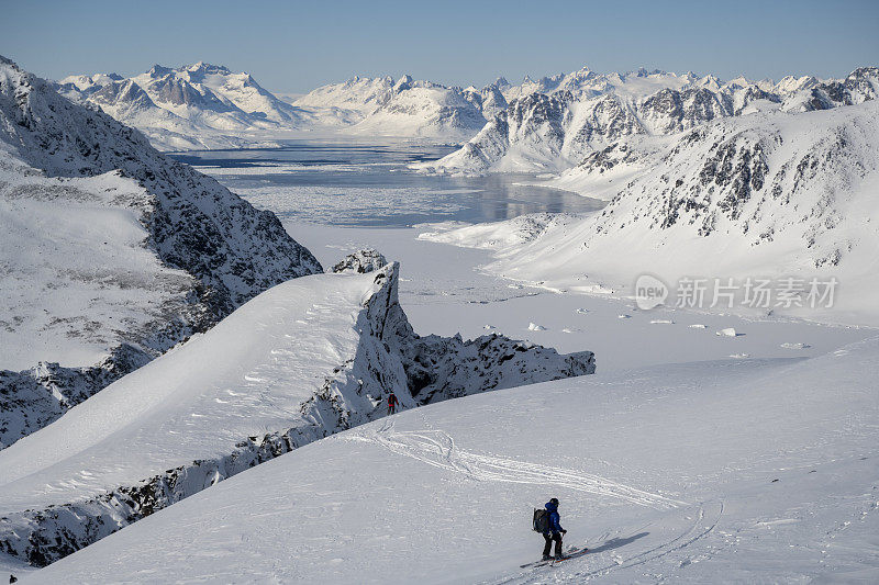 滑雪登山运动员登上白雪皑皑的山峰