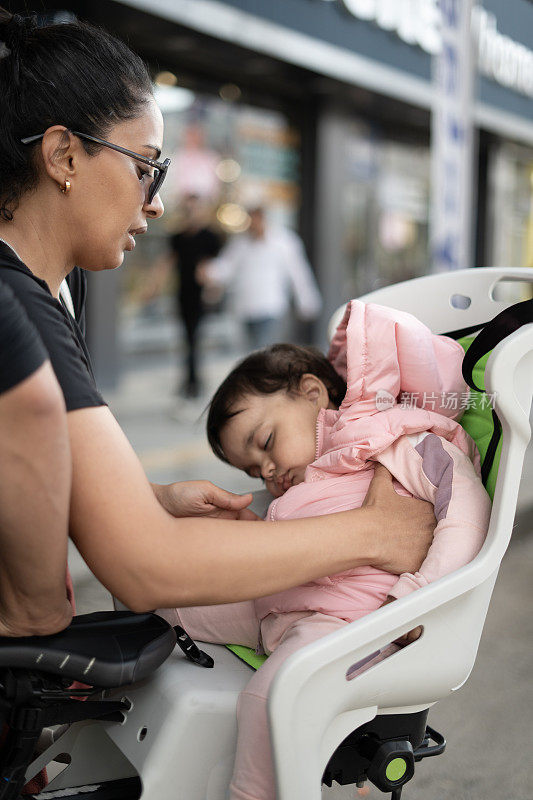 小女孩睡在婴儿自行车座椅上