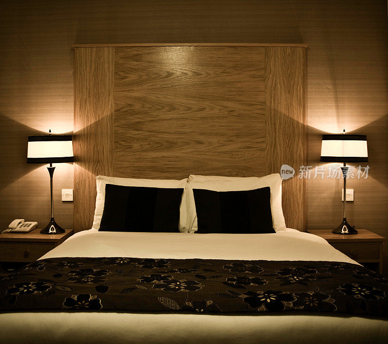 温馨的五星级酒店客房床上配有侧桌灯