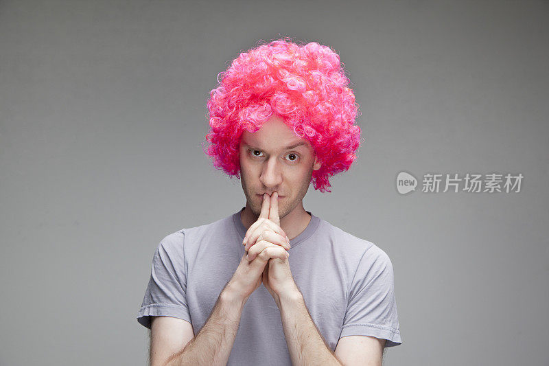 戴着粉色假发的年轻人看起来很严肃