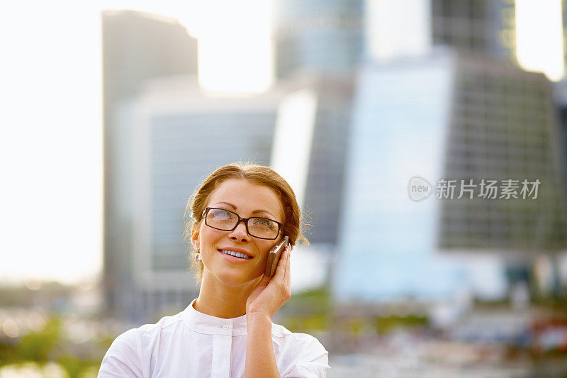 一个女商人在手机上讲话的特写