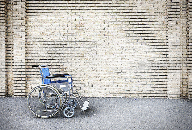 唯一的轮椅停在外面一堵空白砖墙旁边