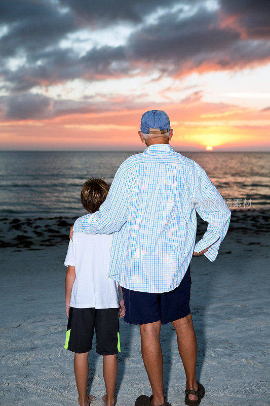 爷爷和孙子在海边看日落