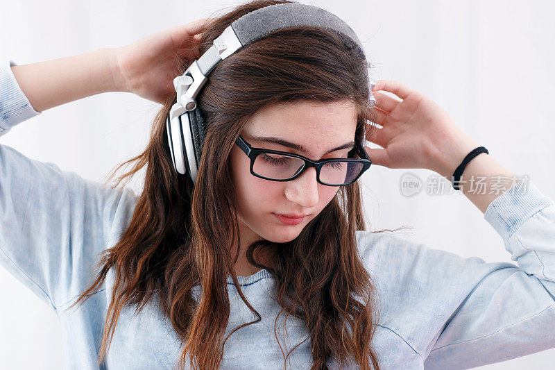 十几岁的女孩戴着耳机听音乐