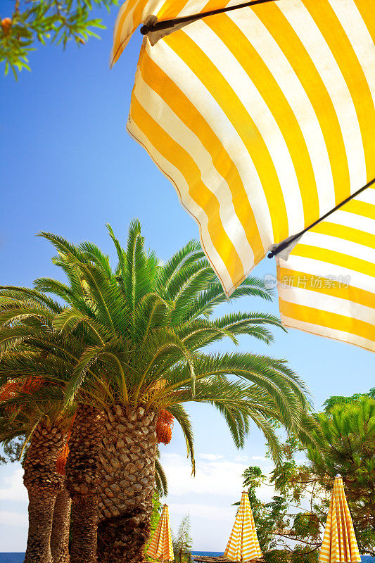 黄色的沙滩伞盖着蓝色的天空
