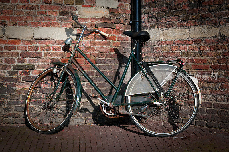 阿姆斯特丹的复古自行车靠在砖墙上