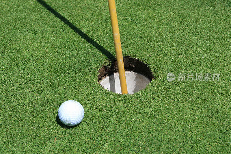 高尔夫球靠近洞和旗帜在果岭