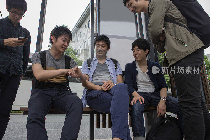 在日本京都，一群日本学生在公交车站等候