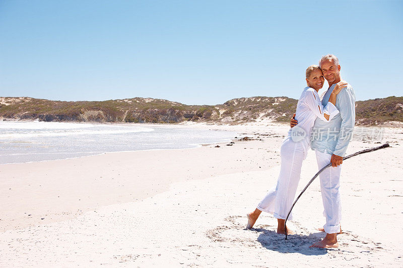 一对可爱的老夫妇在海滩上拥抱着