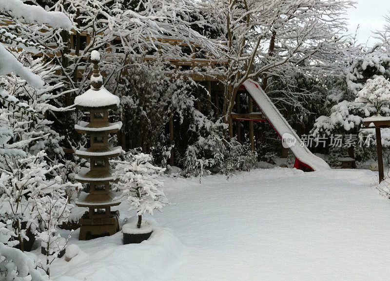 这是一个冬天被雪覆盖的家庭花园