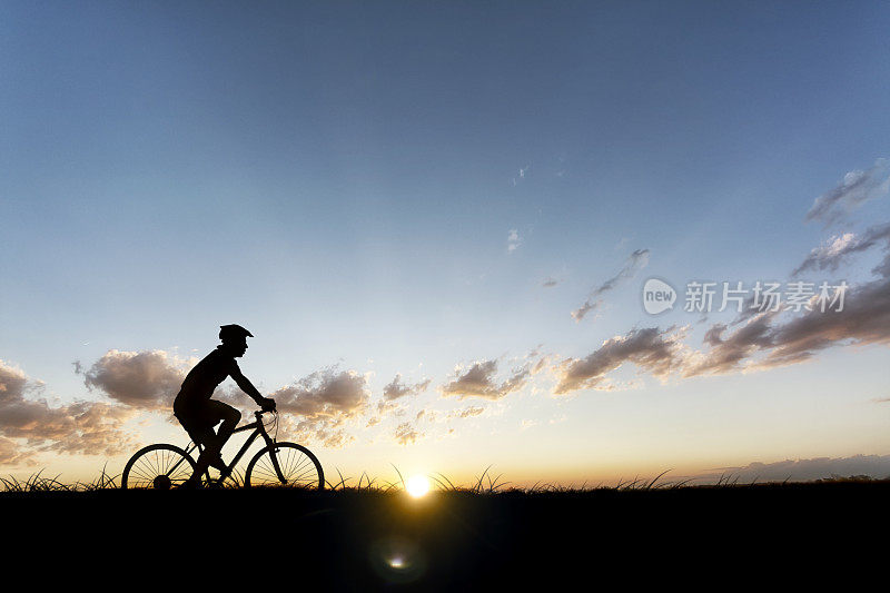 在乡间日落时分骑自行车的人