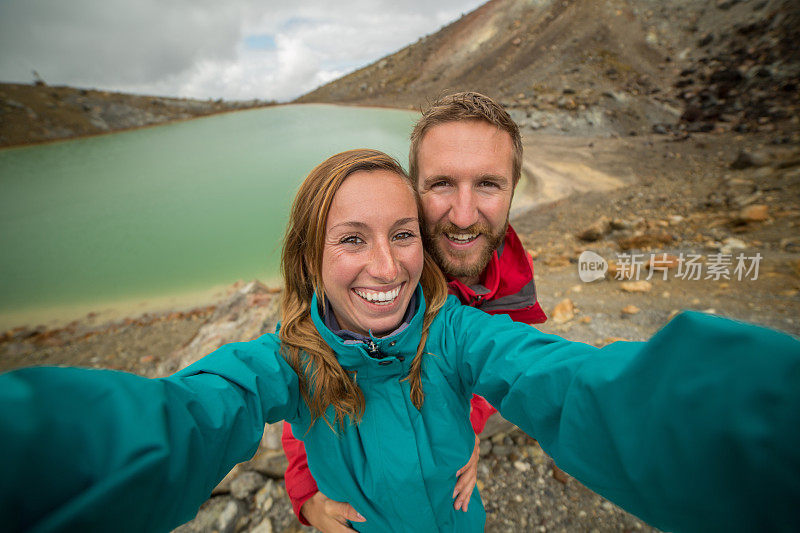 一对年轻夫妇在汤加里罗阿尔卑斯山徒步旅行，拍自拍照