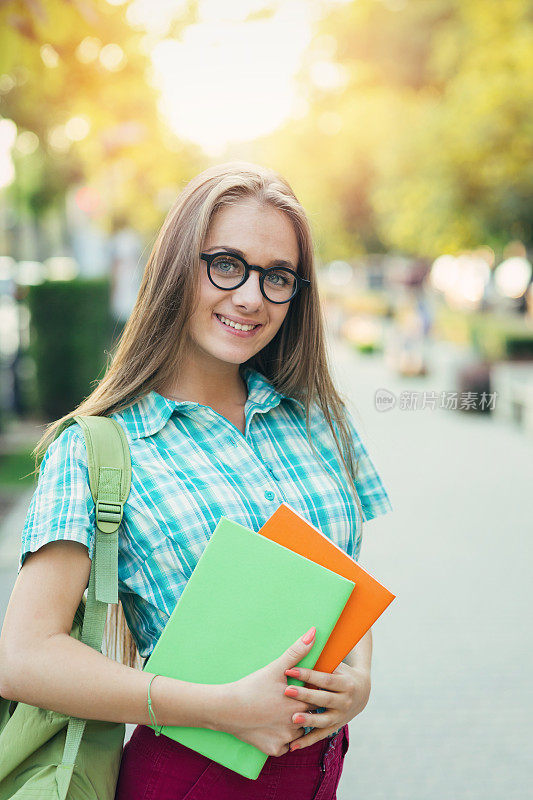 在街上拿着课本的女学生