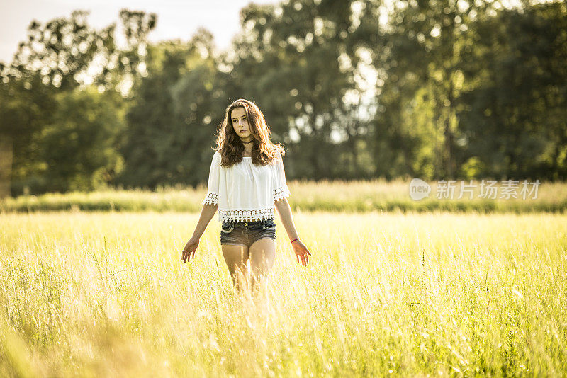 十几岁的女孩站在草地上伸开双臂