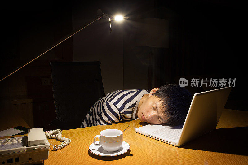 在笔记本电脑上睡觉的亚洲人