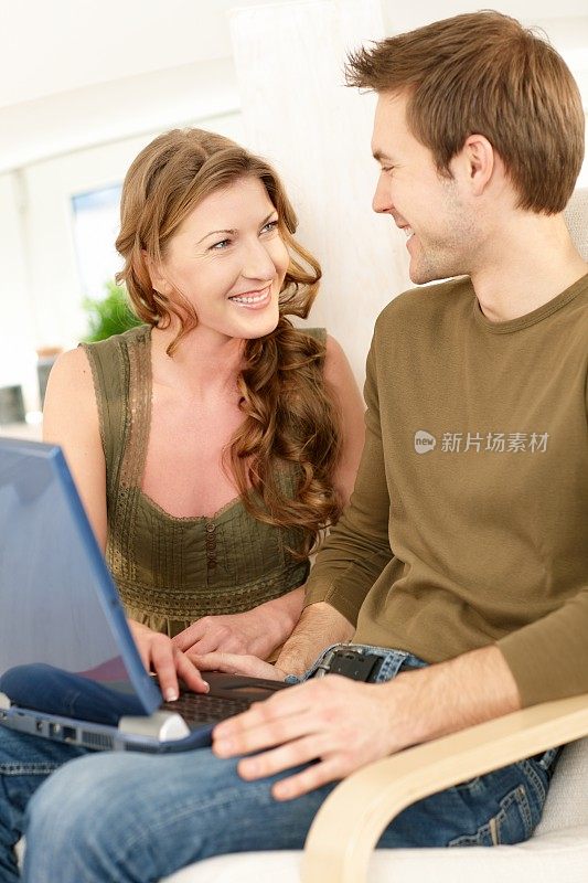 微笑的夫妇在笔记本电脑上浏览互联网
