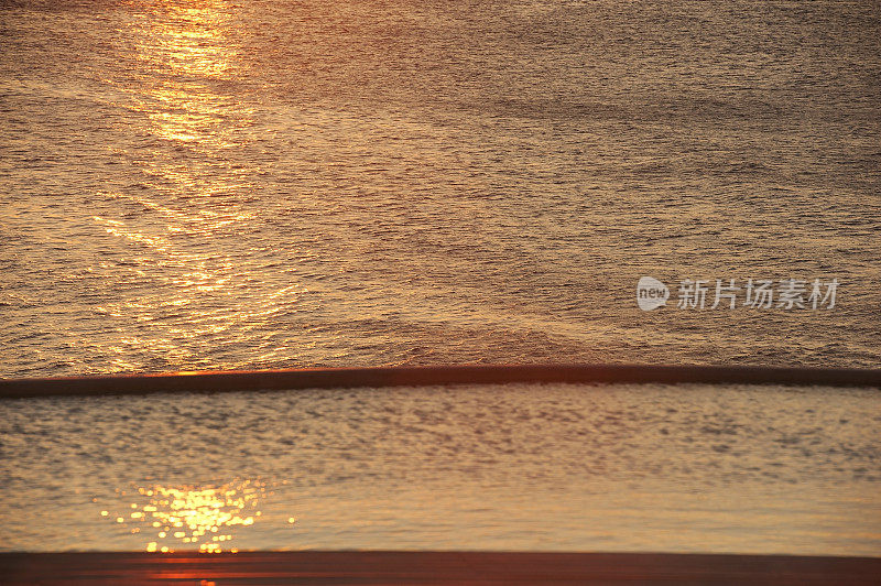 日落时的游泳池和大海