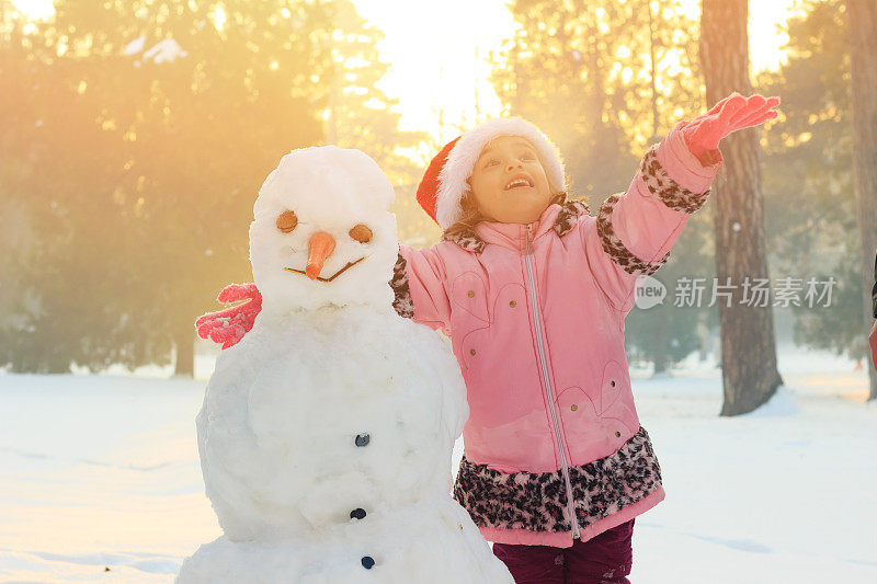 小女孩在外面玩雪人