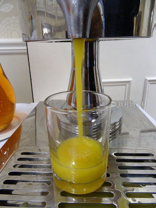 橙汁分配器，将早餐新鲜果汁倒入玻璃杯