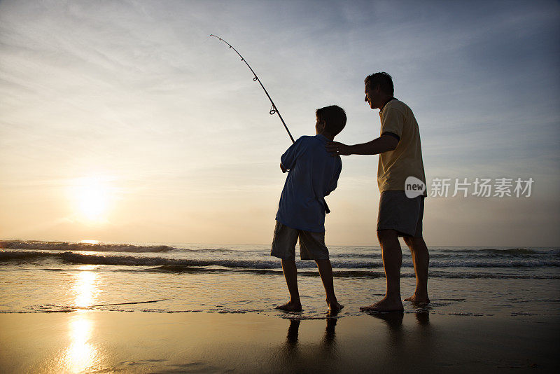 男人和小男孩在海浪中钓鱼