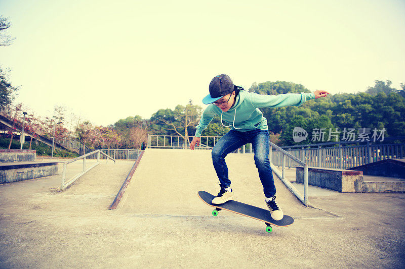 年轻的滑板手在滑板公园玩滑板