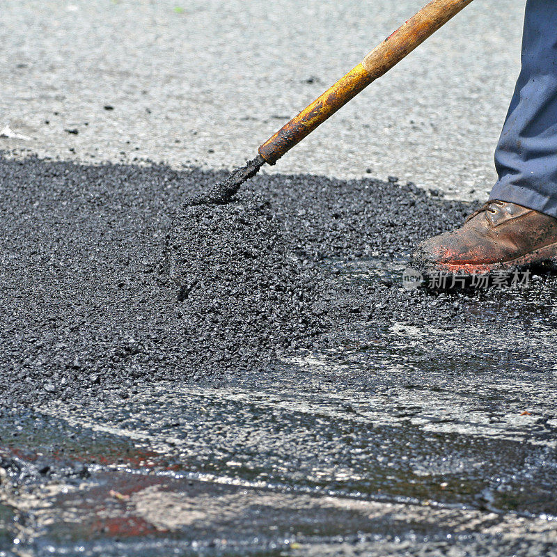 在公路维修现场耙热沥青